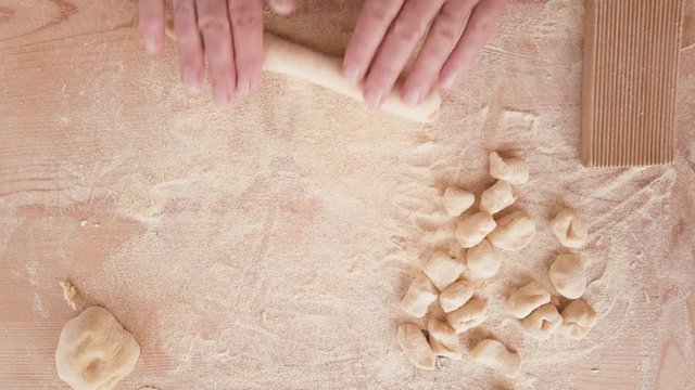 Gnocchi tradizionali di patate, uova e farina, fatti in casa su un tagliere di legno.