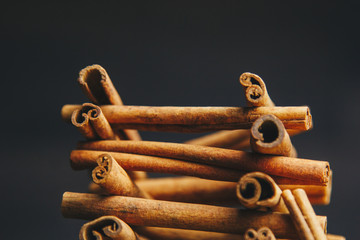 tower of whole sticks of fragrant cinnamon on a wooden rural table. copyspace. composition of seasoning and slide flavoring aromatic spice. close-up. side view, macro