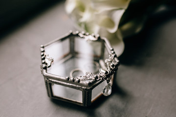 close up wedding rings in rustic box