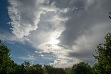 Blue sky with dramatic clouds in direct sun light on a spring afternoon in Issy-les-Moulineaux, France