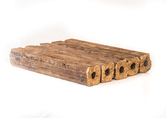 Fuel briquettes folded in rows on a white background. Wooden  briquettes are an environmentally friendly fuel source that are used to start a fire. They are made by pressing of dry sawdust.