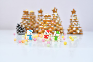gingerbread Christmas tree.Christmas Gingerbread cookie with multi-colors caramel.Sugar white bears in red, green and blue hats and scarfs on white background next to multi-colors caramel