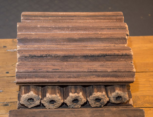Fuel briquettes folded in rows on a white background. Wooden  briquettes are an environmentally friendly fuel source that are used to start a fire. They are made by pressing of dry sawdust.