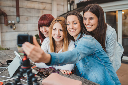 Group of young beautiful women bloggers talking while recording a review in happy moment - Vlog concept - Four millennial made a video blog about their experiences - Influencers take a selfie together