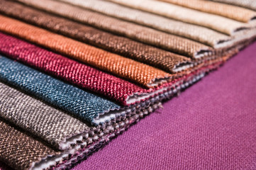 Colorful and bright fabric samples of furniture and clothing upholstery. Close-up of a palette of...