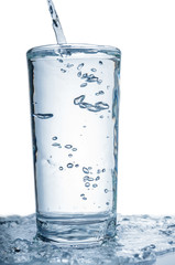 Pouring water in glass isolated on white background