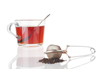 Tea strainer and tea cup on white background. Back focus