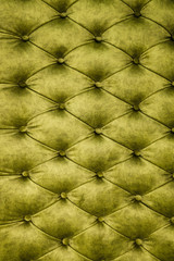 Velor lime surface of sofa close-up. Training equipment-velor mats tightened with buttons. Yellow chesterfield style quilted upholstery background