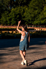 Beautiful young woman in denim overalls on the go-kart track