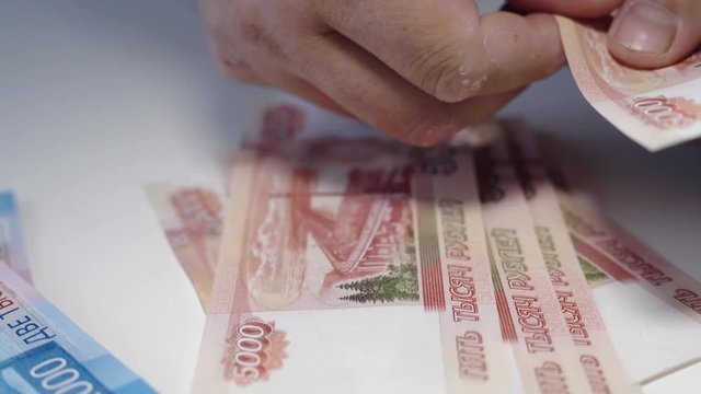 man giving money, Russian Ruble banknotes, over his desk i bribery and corruption concept.russian rubles banknotes. Financial theme. stack of banknotes in a man's hand.