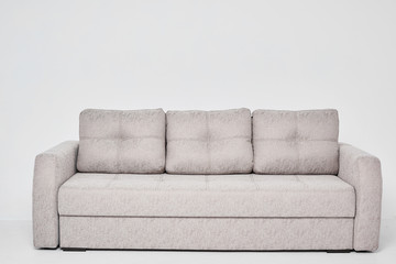 Light grey classic sofa with three pillows isolated at white background