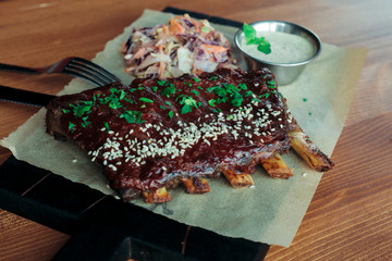 Grilled ribs with spices sesame and greens decorated with garlic sauce and salad