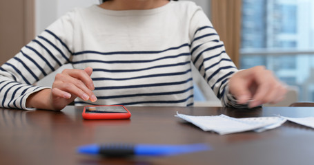 Woman record the bill on cellphone at home