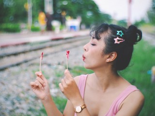 girl blowing bubbles in the park.