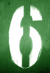 Number 6 in stencil on grungy metal wall in green tone.