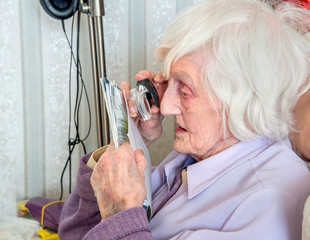 Visually impaired elderly woman with magnifyer