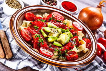 Pasta with herbs and vegetables on wooden background