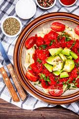 Pasta with herbs and vegetables on wooden background