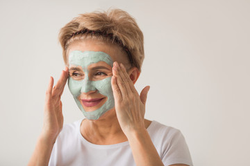 beautiful elderly woman with a wellness cream face mask