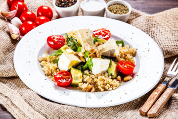 Salad with avocado and cheese on wooden background