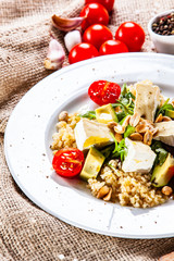 Salad with avocado and cheese on wooden background