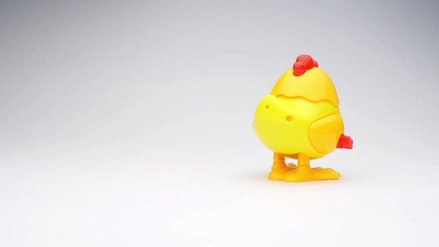 Clockwork chick toy hopping around. Slow motion.
