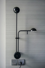 Black metal modern lamps hanging against wooden wall