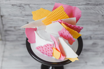 Stylish colored cake staying on black tray on the white wooden background. Birthday party celebration gift.