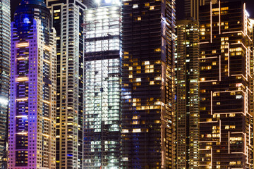 Fototapeta na wymiar Close-up view of some modern skyscrapers and towers illuminated at night. Dubai Marina, Dubai, United Arab Emirates, UEA.