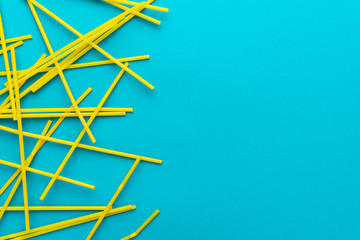 top view of cocktail straws on turquoise blue background with copy space