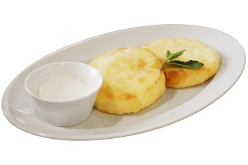 Ricotta pancakes, cottage cheese pancakes on a white plate with sour cream