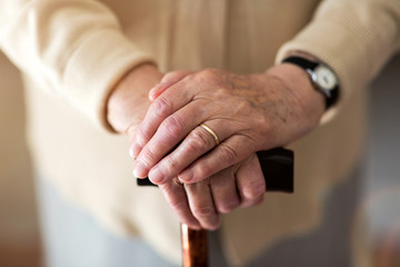 Close-up of senior's hand leaning on cane