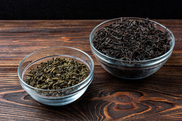 Black and green tea on dark wooden background.
