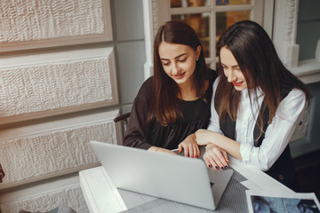 Girls and computer. Beautiful businesswomen are working. Womens sit at the table