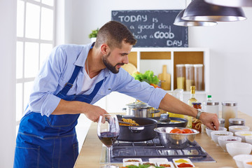 Smiling and confident chef standing in large kitchen