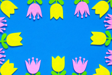 Yellow and pink felt tulip flower cutouts on a blue background