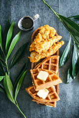 Chicken and Waffles with Butter and Syrup on Dark Background
