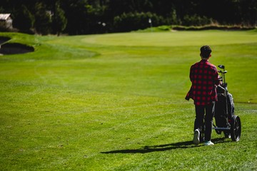 A young man walking on a golf course 
