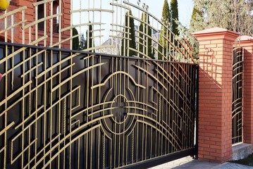 brown gate and metal fence with forged pattern on the street