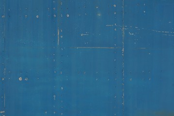 blue metal background from an old dark shabby iron wall with a seam