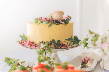 Very beautiful and fashionable wedding cake decorated with fresh flowers. Sweet cake for the...