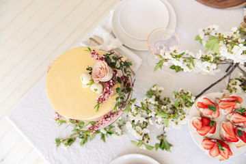 Very beautiful and fashionable wedding cake decorated with fresh flowers. Sweet cake for the wedding.