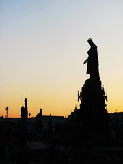 Fototapeta premium Black silhouette of the monument statue on the background of the evening sunset in Prague in the Czech Republic.