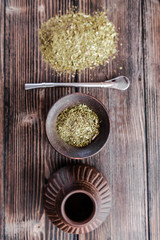 A yerba mate tea set of calabash gourd, ceramic cup, bombilla and grounded tea leafs on the wooden...