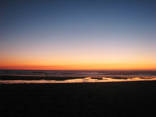Fototapeta na wymiar Dark blurred sunset on the sandy shore of the ocean.