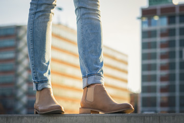 Female legs in jeans and leather shoe. Fashion woman wearing casual clothing in city.