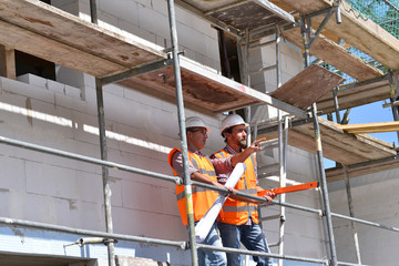 construction manager and architect on site during the construction of a house - planning and...