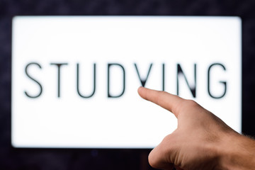 Man pointing to a screen with inscription STUDY showing importance of knowledge nowadays
