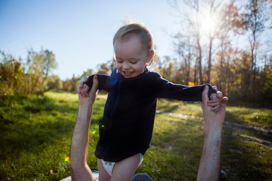 Portrait of smiling toddler girl with her father on a meadow