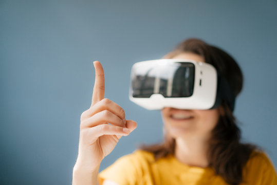 Woman wearing VR glasses, watching raised finger